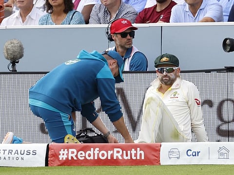Australia's Nathan Lyon receives medical attention after sustaining an injury during the second Test against England on June 29 at Lords.