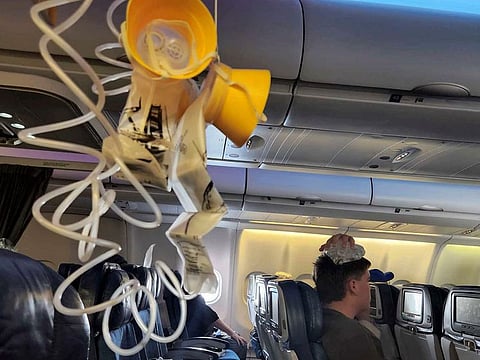 This photo provided by Tara Goodall shows dropped oxygen masks and a man with an ice pack on his head after severe turbulence on board a Hawaiian Airlines flight from Honolulu to Sydney, June 30, 2023.