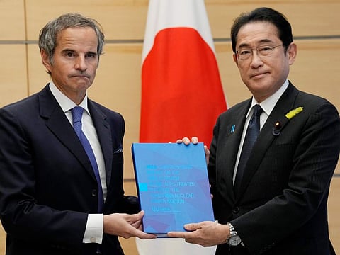 Rafael Mariano Grossi, Director General of the International Atomic Energy Agency, left, presents IAEA's comprehensive report on Fukushima Treated Water Release to Japanese Prime Minister Fumio Kishida, right, at the prime minister's office Tuesday, July 4, 2023 in Tokyo.