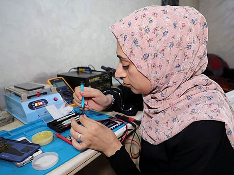 Palestinian woman Walaa Hammad repairs mobile phones at her home in Gaza City.
