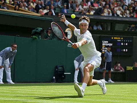 Britain's Liam Broady stretches for a backhand return to Norway's Casper Ruud during their match on the fourth day of the Wimbledon Championships at The All England Tennis Club in Wimbledon on Thursday.