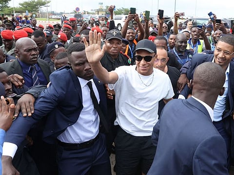 Paris Saint-Germain and France football star striker Kylian Mbappe greets crowds gathered outside at the Yaounde Airport on Thursday.