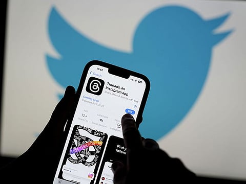 The Threads app, operated by Meta Platforms Inc., on a smartphone, besides a Twitter Inc. logo, arranged in Madrid, Spain, on Tuesday, July 5, 2023. Threads is a “text-based conversation app” that’s widely seen as an alternative to Twitter.