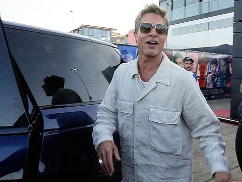 Actor Brad Pitt cheers fans leaving the paddock after after the second free practice at the British Formula One Grand Prix at the Silverstone racetrack, Silverstone, England.