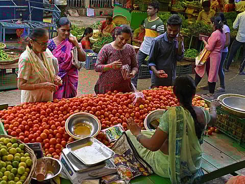 Customers buy tomatoes at a vegetable market in Hyderabad.