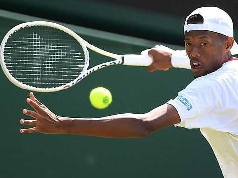 US player Christopher Eubanks plays a forehand return to Greece's Stefanos Tsitsipas during their men's singles match of the Wimbledon Championships at The All England Tennis Club on Monday