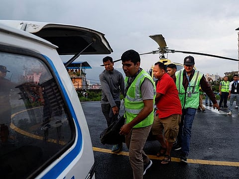 People carry the body of a person killed in a helicopter crash belonging to Manang air, at Tribhuvan University Teaching Hospital in Kathmandu, Nepal July 11, 2023.