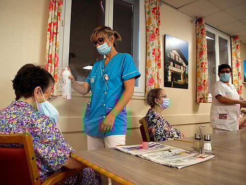 A health worker refreshes a resident of a retirement home in Isturitz, southwestern France, June 15, 2022.