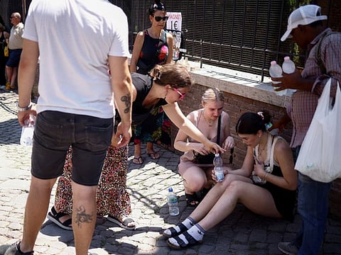 A tourist from the UK receives help near the Colosseum after fainting during a heatwave across Italy, in Rome, Italy July 11, 2023.