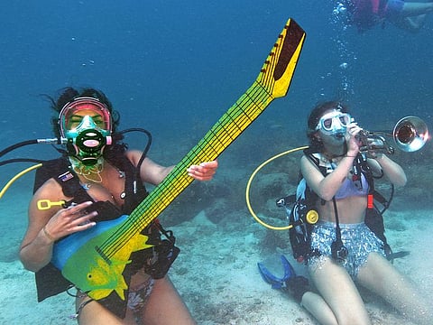 Kelly Angel, left, and Kara Norman, right, pretend to play underwater musical instruments, at the Lower Keys Underwater Music Festival in the Florida Keys National Marine Sanctuary near Big Pine Key.