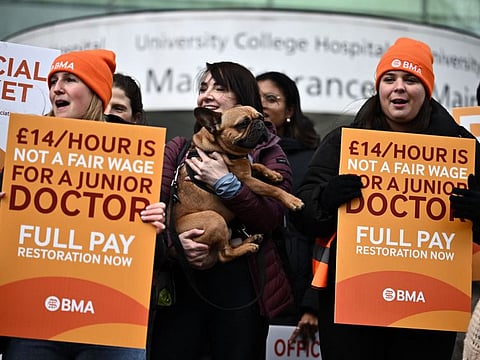 People hold British Medical Association (BMA) branded placards calling for better pay, as they stand on a picket line outside University College Hospital (UCH) in central London. Tens of thousands of doctors in Britain’s state-funded health service launched a five-day walkout on Thursday.
