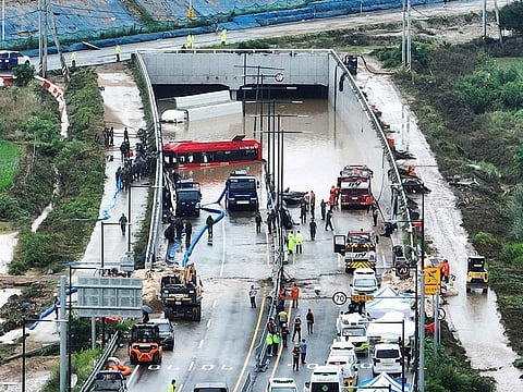 Rescuers work to search for survivors along a road submerged by floodwaters leading to an underground tunnel in Cheongju, South Korea.