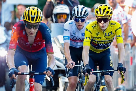 Jumbo-Visma's Danish rider Jonas Vingegaard wearing the overall leader's yellow jersey (right) and UAE Team Emirates' Slovenian rider Tadej Pogacar wearing the best young rider's white jersey cycle in the final ascent of Saint-Gervais-les-Bains on Sunday.