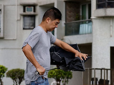 A man walks past with an umbrella as Typhoon Talim approaches, in Hong Kong, China.