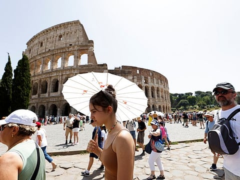 People walk near the Colosseum during a heat wave across Italy as temperatures are expected to rise further in the coming days, in Rome, Italy July 17, 2023.