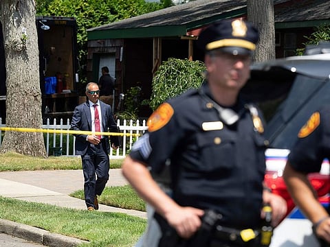 Police officers stand guard as law enforcement searches the home of Rex Heuermann, Saturday, July 15, 2023, in Massapequa Park, New York.