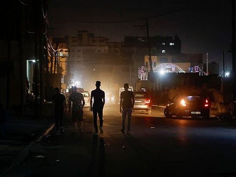 Palestinians walk in the street amid a heatwave and lengthy power cuts at Shati refugee camp in Gaza City, July 17, 2023.