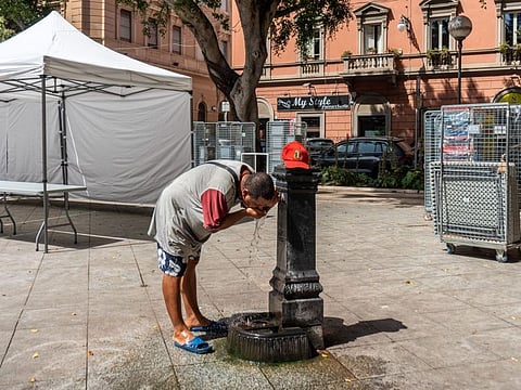A man refreshes himself at a public fountain in Cagliari, Sardinia, Italy, on Wednesday, July 19, 2023.