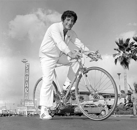 Singer Tony Bennett poses on a bicycle in front of the Sahara hotel and casino in Las Vegas, Nevada, U.S. March 2, 1977.