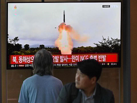 People watch a television screen showing a news broadcast with file footage of a North Korean missile test. Pyongyang routinely conducts weapons tests.