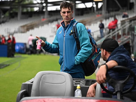 Australia's Pat Cummins speaks to a member of the groundstaff as rain delays the start of play on day five of the fourth Ashes Test at Old Trafford cricket ground in Manchester on Sunday.