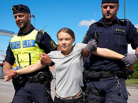 Climate activist Greta Thunberg is detained by police during an action for blocking the entrance to an oil facility in Malmo, Sweden, on Monday, July 24, 2023.
