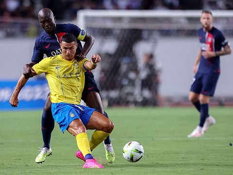 Paris Saint-Germain's Danilo Pereira (back) fights for the ball with Al Nassr's Cristiano Ronaldo during the friendly match at Nagai Stadium in Osaka on Tuesday.
