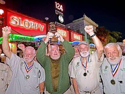 Gerrit Marshall, center, hoists his trophy after winning the Hemingway Look-Alike Contest.