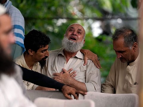 A man cries outside the mortuary after he lost his son by monsoon rains on the outskirts of Islamabad, on July 19, 2023.