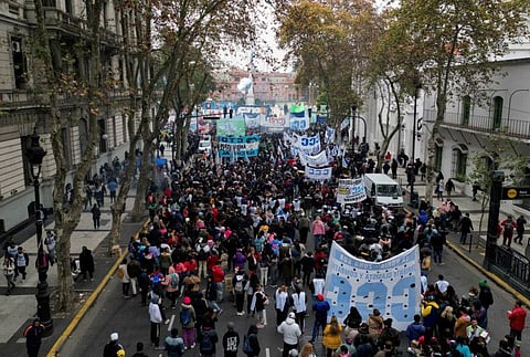 People gather near the presidential palace during a protest as inflation is hitting 114%, hurting salaries and spending power, with many blaming tighter policies they say are due to the deal with the IMF, in Buenos Aires.