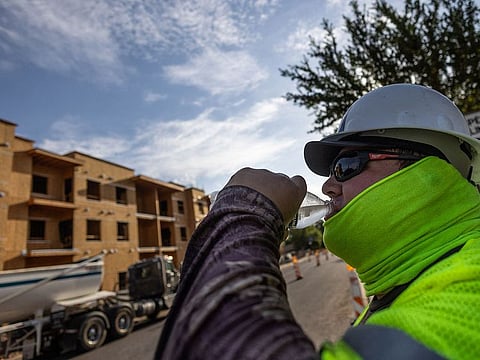 A construction worker drinks cold water during a heat wave where temperatures rise over 110 degrees Fahrenheit for 27 consecutive days, in Scottsdale, at the Phoenix metro area, Arizona.