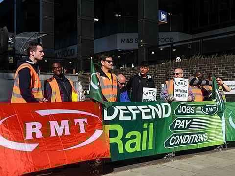 Striking workers on a picket line during a strike by railway workers from the National Union of Rail, Maritime and Transport Workers (RMT), at Euston station in London, UK.