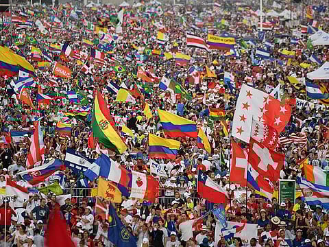 Pilgrims cheer and wave flags as Pope Francis arrives to preside over an evening vigil with young people at the Campo San Juan Pablo II in Panama City, on January 26, 2019