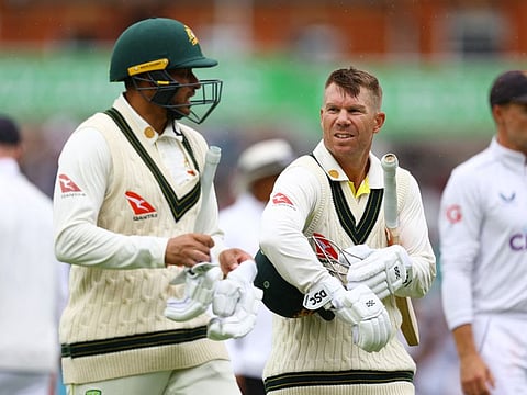 Australia's David Warner and Usman Khawaja talk as they leave the field on the fourth day of the Ashes Test against England at The Oval, London, on Sunday.