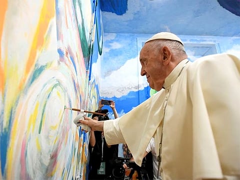 Pope Francis paints a mural during a meeting with young members of Scholas Occurrentes in Cascais, Portugal.