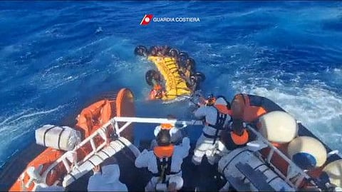 This handout photograph taken on August 5, 2023 by Italian Coastguard (Guardia Costeria) and released on August 6, 2023, shows a rescue operation that took place south of Lampedusa, consisting in rescuing 57 migrants, also recovering the lifeless bodies of a woman and a minor on board.