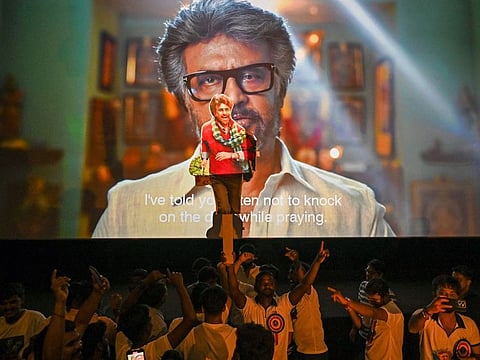 Fans dance during the screening of Indian actor Rajinikanth's new Tamil-language movie 'Jailer' on the first day of its release, inside a theatre in Mumbai on August 10, 2023