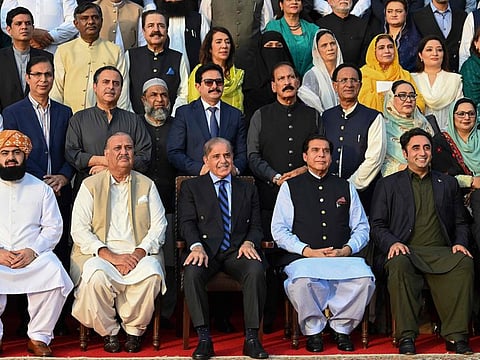 Pakistan's Prime Minister Shehbaz Sharif (third left in front row) poses for a photograph with parliamentarians after current last session of National Assembly outside the parliament house building in Islamabad on August 9, 2023.