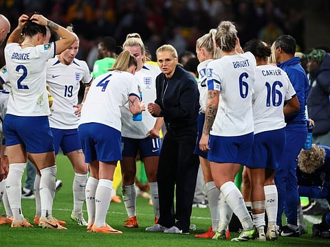 England's head coach Sarina Wiegman talks with players during the Women's World Cup round of 16 match against Nigeria in Brisbane, Australia, Monday, Aug. 7, 2023. (AP Photo/Tertius Pickard)