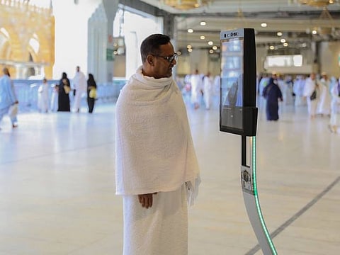 A pilgrim speaks to a robot.