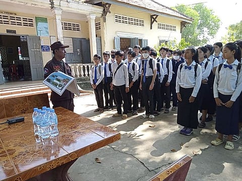 In this photo released by the Cambodia Mine Action Center, CMAC, a deminer expert, left, explains students at Queen Kosamak High School in Kratie Province, northeastern of Phnom Penh, Cambodia Sunday, Aug. 13, 2023. Cambodian authorities have temporarily closed the high school where thousands of pieces of unexploded ordinance from the country's nearly three decades of civil war have been unearthed.