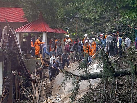 Rescue workers remove the debris as they search for survivors after a landslide following torrential rain in Shimla in the northern state of Himachal Pradesh, India.