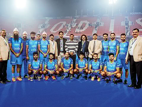 Odisha sports minister, Tusharkanti Behera (standing, centre) and Vineel Krishna, Special Secretary to the Odisha Chief Minister, seen with the Indian hockey team, sporting the Odisha logos on their team jerseys