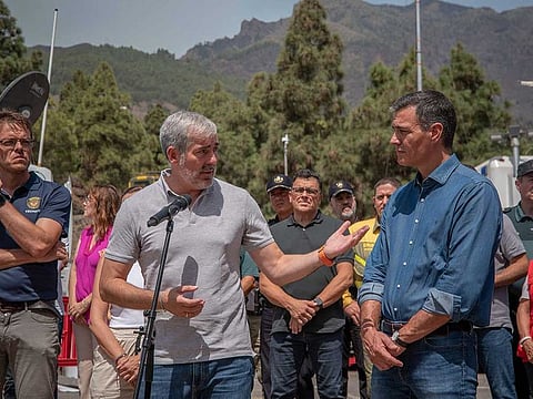Spain's acting Prime Minister Pedro Sanchez listens while President of the Government of the Canary Islands Fernando Calvijo (L) speaks during a visit to the emergency units' advanced control post (PMA-Puesto de Mando Avanzado) in Arafo, on Tenerife island on August 21, 2023.