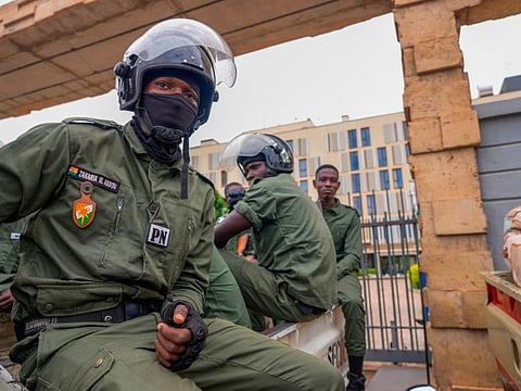 Nigerien police officers sit outside the customs offices in Niamey, Niger.