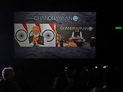 People watch as India's Prime Minister Narendra Modi (L) congratulates the Indian Space Research Organisation (ISRO) for the successful lunar landing of Chandrayaan-3 spacecraft on the south pole of the Moon during a live stream of the event at a museum in Kolkata on August 23, 2023.