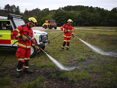 Firefighters from the Surrey Fire and Rescue Service use small pressure hoses used to extinguish small fires.