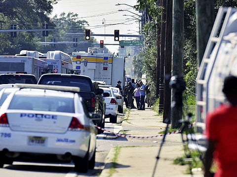 Emergency personnel surround a Dollar General store after a white man armed with a high-powered rifle and a handgun killed three Black people before shooting himself.