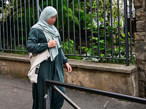 A photograph taken on August 28, 2023 shows a woman wearing an abaya walking in the streets of Paris. Education Minister Gabriel Attal said on Sunday that the dresses, worn by some Muslim girls, would no longer be allowed in schools.