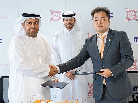 Rashid Abdullah Al Obed (left), Managing Director of Sharjah Media City, and Hyoung-Mun Choi (right), Director of Business Centre and Head of projects at Munhwa Broadcasting Corporation (MBC), during the MoU signing ceremony, in the presence of Dr Khalid Omar Al Midfa (centre), Chairman of Sharjah Media City.